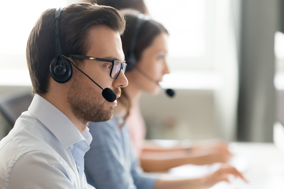 Bild på kundtjänstpersonal med headset framför datorer